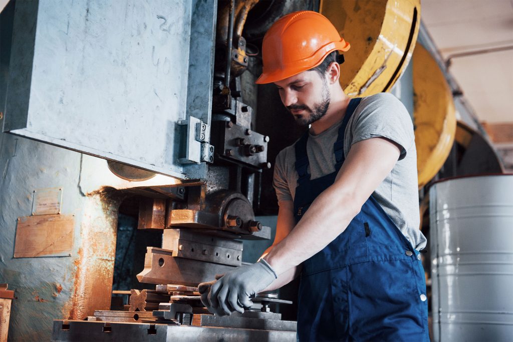 a man is working with machine tool to shape a metal