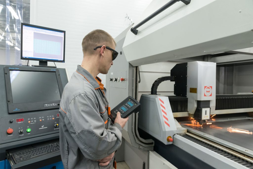 a man is cutting metal plate by CNC machine tools